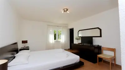 a bedroom with a bed and a mirror and a chair at Villa Lotus, CD 283 - Cleverdetails in Vilamoura