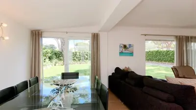 a living room with a glass table and chairs at Villa Lotus, CD 283 - Cleverdetails in Vilamoura