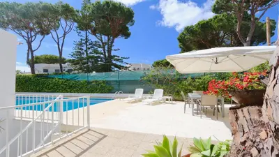 a patio with an umbrella and a pool at Villa Lotus, CD 283 - Cleverdetails in Vilamoura