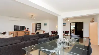 a living room with a couch and a glass table at Villa Lotus, CD 283 - Cleverdetails in Vilamoura