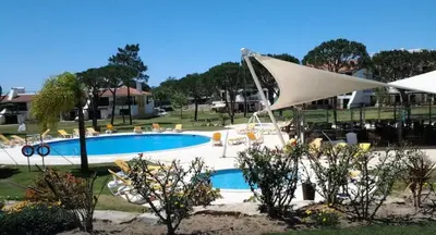 a rock cliff next to a beach and the ocean at Casa Joanna Vila Sol Golf Village in Quarteira