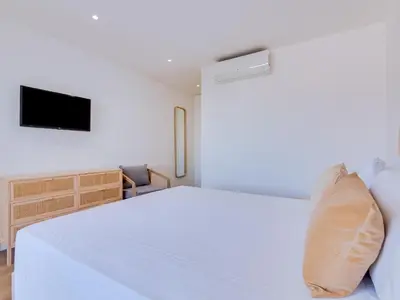 a bedroom with a white bed and a television at AL Apartamento Alsol in Quarteira