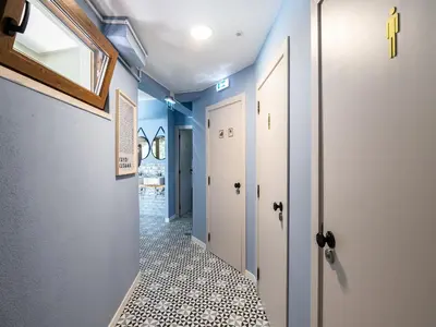 a hallway with blue walls and a tile floor at Walk in Hostel Faro Airport in Faro