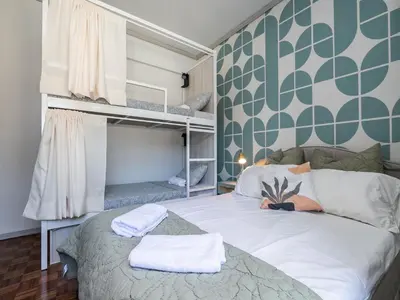 a small bedroom with a bed with towels on it at Walk in Hostel Faro Airport in Faro