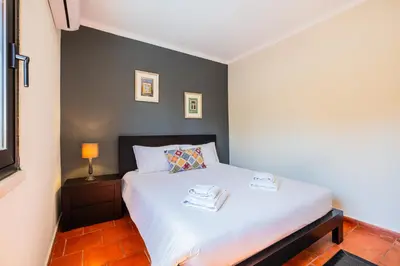a bedroom with a bed with two towels on it at Orange Tree House in Albufeira