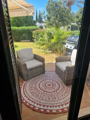 a patio with two chairs and a rug at ADO HOUSE Albufeira in Albufeira