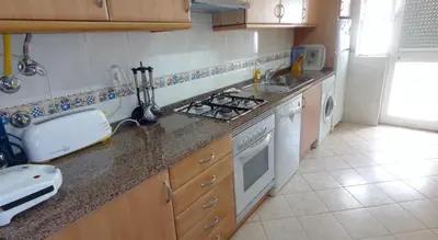 a kitchen with a sink and a stove top oven at Apartamento Avenida da Liberdade in Albufeira