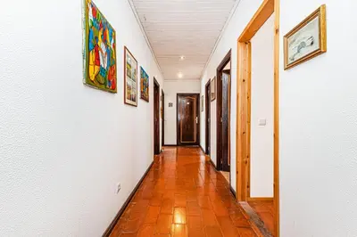 a hallway with paintings on the walls of a house at Villa Oliva - Maison 6 chambres in Vilamoura