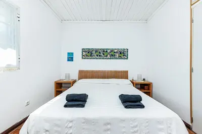 a bedroom with a bed with two blue pillows on it at Villa Oliva - Maison 6 chambres in Vilamoura
