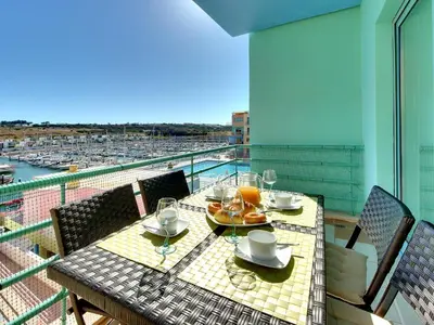 a table on a balcony with a view of a harbor at Marina Sea Residence in Albufeira