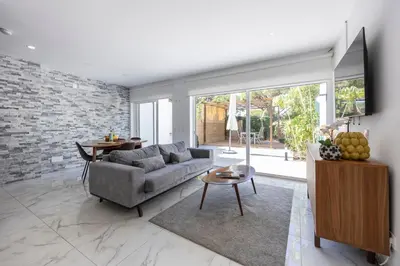 a living room with a couch and a brick wall at Casa Verde Vilamoura in Quarteira
