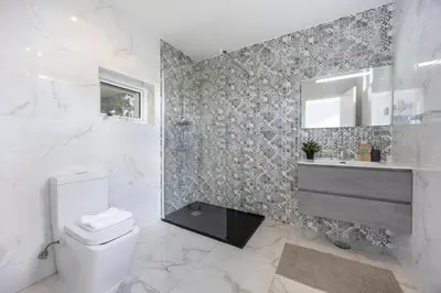 a bathroom with a toilet and a sink and a mirror at Casa Verde Vilamoura in Quarteira