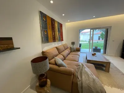 a living room with a brown couch and a table at Modern Apartment with balcony and direct access to the pool in Albufeira