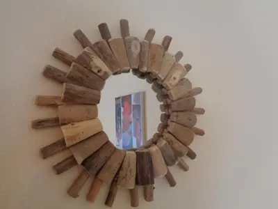 a wooden sunburst mirror hanging on a wall at Apartamento Praia dos Salgados in Albufeira