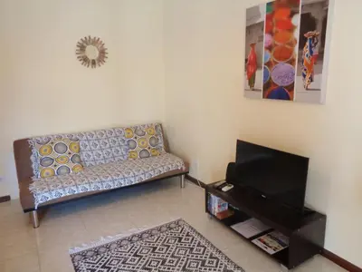 a living room with a couch and a television at Apartamento Praia dos Salgados in Albufeira