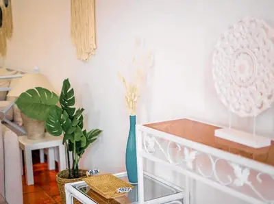 a room with a table with a blue vase and plants at Albufeira Boho Apartment in Albufeira