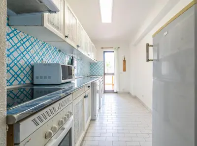 a kitchen with a stove and a microwave at Albufeira Boho Apartment in Albufeira