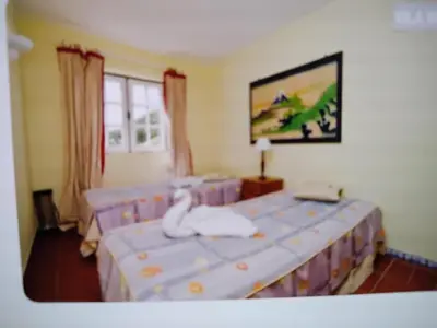 a bedroom with two beds with white swans on them at Nice flat in pretty condo in Quarteira