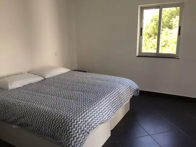 a bed in a white room with a window at Casa com 3 suites, jacuzzi , en Albufeira in Albufeira