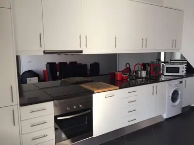 a kitchen with white cabinets and a stove top oven at Casa com 3 suites, jacuzzi , en Albufeira in Albufeira