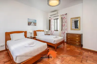 a bedroom with two beds and a dresser in it at #232 Vila Girasol 33 by Home Holidays in Albufeira