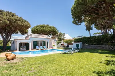 a house with a swimming pool in a yard at Villa Moura by HelloVacations in Loulé