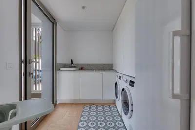 a kitchen with a washing machine and a sink at SUNSET VILLA - Luxury villa with superb pool and great views in Faro