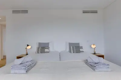a white bed with two pillows on top of it at SUNSET VILLA - Luxury villa with superb pool and great views in Faro
