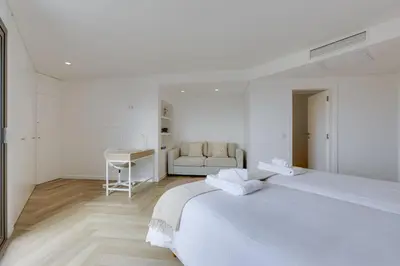 a white bedroom with a bed and a couch at SUNSET VILLA - Luxury villa with superb pool and great views in Faro