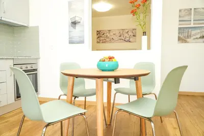 a kitchen with a wooden table and chairs at Pilar Apartment in Albufeira