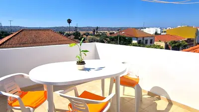 a white table and chairs on a balcony at Apart Alfarrobinha - T2 - BY BEDZY in Tunes