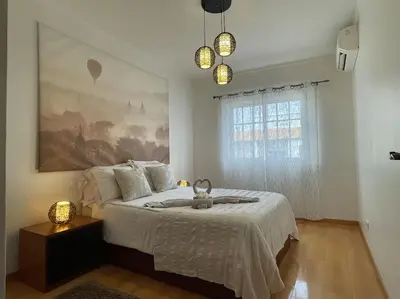 a bedroom with a bed and a painting on the wall at The Luna Apartment Faro - 2 Bedroom Private Apartment in Faro