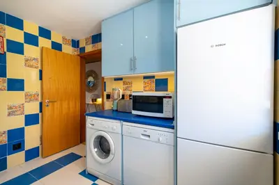 a kitchen with a washing machine and a microwave at Romantic with private Hot Tub & Parking - big pool - Marina access in Albufeira