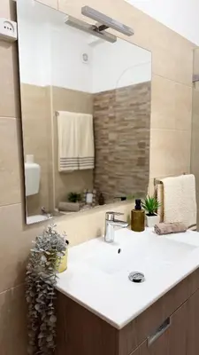 a bathroom with a sink and a large mirror at Apartamentos do Atlantico in Albufeira
