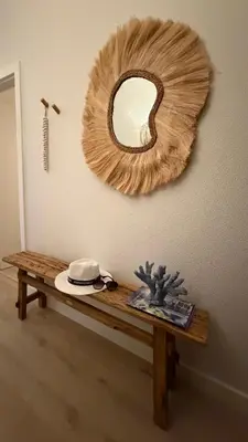 a mirror hanging on a wall with a wooden table at Apartamentos do Atlantico in Albufeira
