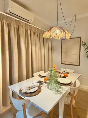 a white dining room table with chairs and a chandelier at Apartamentos do Atlantico in Albufeira