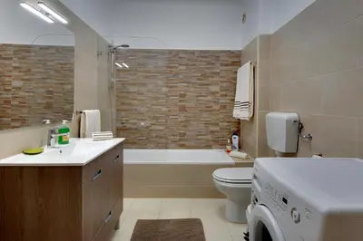 a bathroom with a tub and a toilet and a sink at Apartamentos do Atlantico in Albufeira