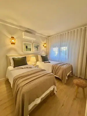 a hotel room with two beds and a window at Apartamentos do Atlantico in Albufeira