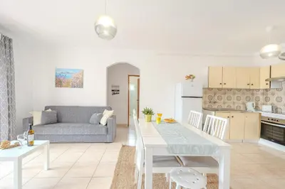 a kitchen and living room with a table and a couch at Apartamento Briza by Sunnyway in Albufeira