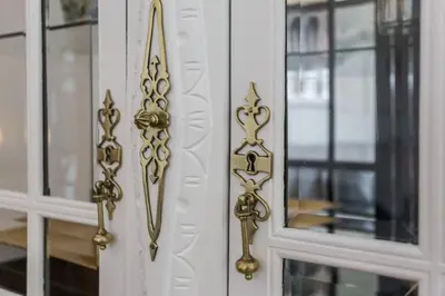 a white door with gold knobs on it at Charming house with terrace near the city center in Faro