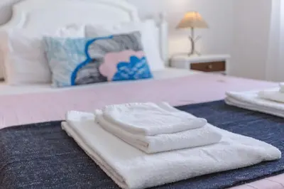 a pile of towels sitting on top of a bed at Color me Happy - 2 bedrooms apartment near Forum Algarve in Faro