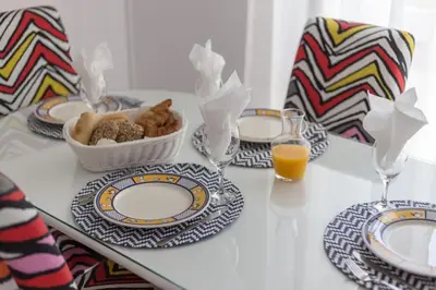 a table with plates of food and a glass of orange juice at Color me Happy - 2 bedrooms apartment near Forum Algarve in Faro