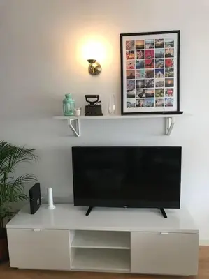 a flat screen tv sitting on top of a white entertainment center at Home away from Home in Faro
