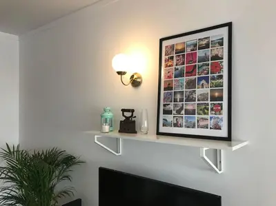 a shelf on a wall with a picture on it at Home away from Home in Faro