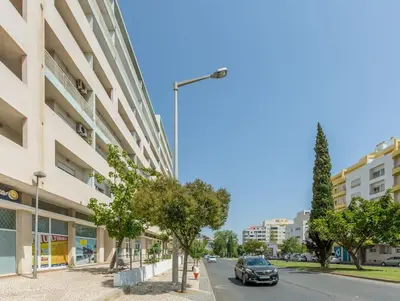 a car driving down a street next to a building at Home away from Home in Faro