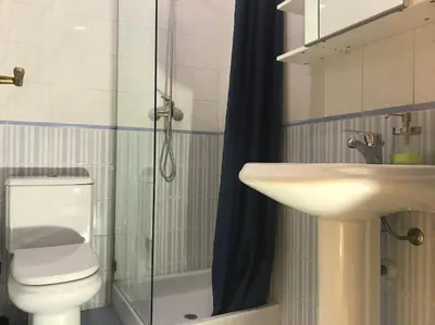 a bathroom with a sink and a toilet and a shower at Home away from Home in Faro