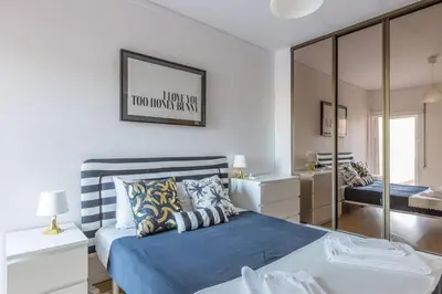 a bedroom with a blue bed and a mirror at Home away from Home in Faro
