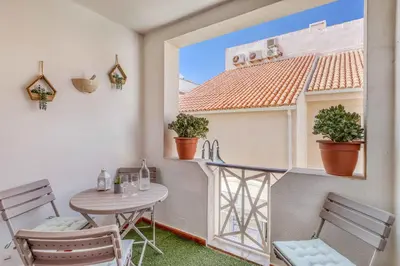 a small balcony with a table and chairs at T2 duplex na Marina de Vilamoura in Loulé