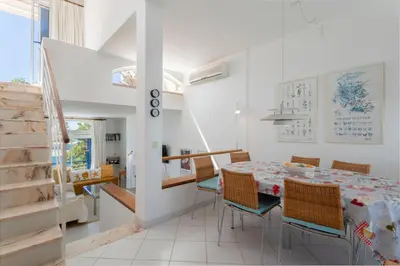 a white dining room with a table and chairs at TAC - Windmill OceanFront Villa in Albufeira