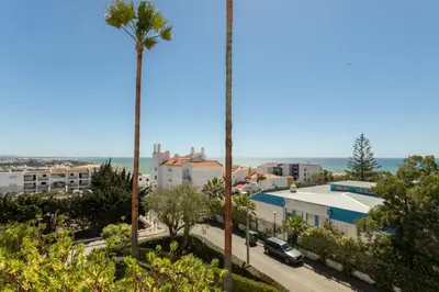 a view of a city with palm trees and the ocean at TAC - Windmill OceanFront Villa in Albufeira